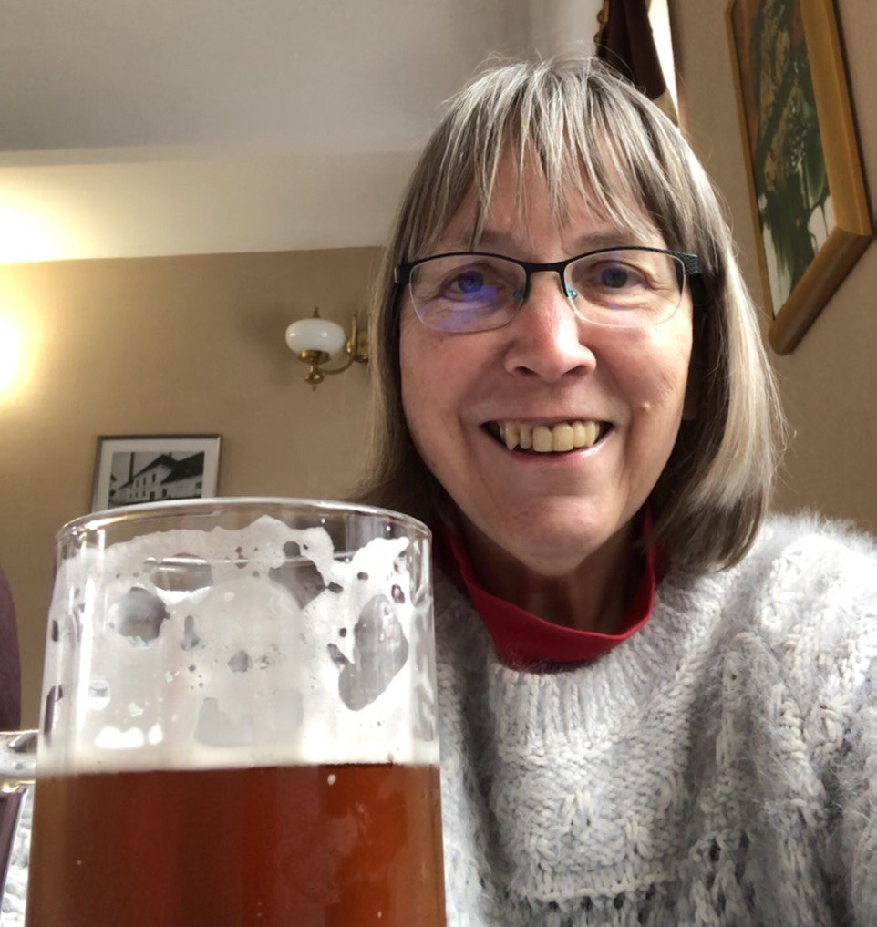 Sarah Shaw smiling and holding a beer